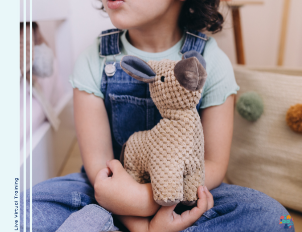 Child wearing blue dungarees holding on to a teddy