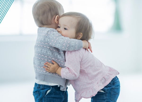 Two toddlers hugging