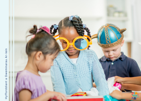 Picture shows children dressing up. In the centre of the picture a child wears oversized glasses 