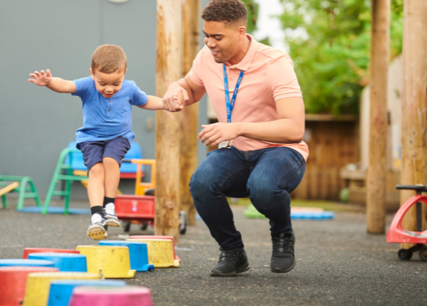 Adult helping child play on blocks