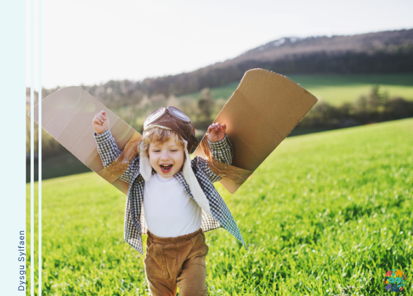 Picture shows a child dressed up as a pilot with cardboard wings 