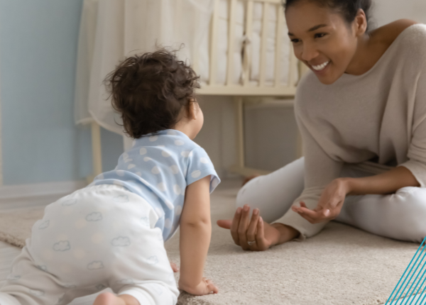 Adult encouraging crawling baby forward