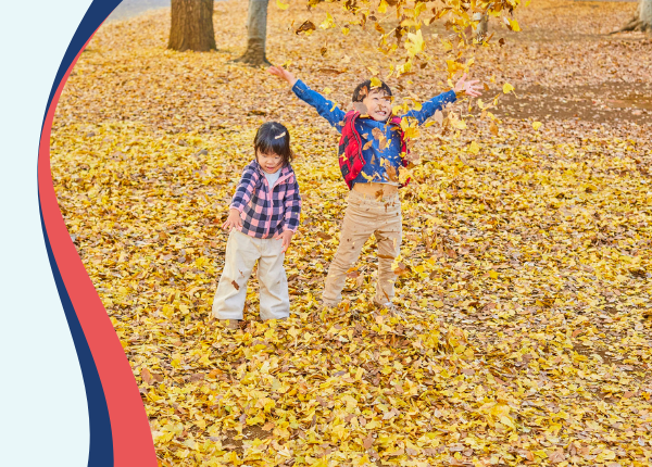 Two children playing in leaves