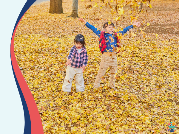 Two children playing in leaves