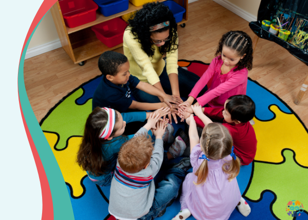 Children all in a circle stacking hands