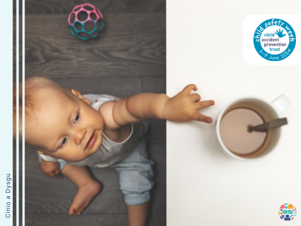 Baby reaching up towards a mug of hot tea