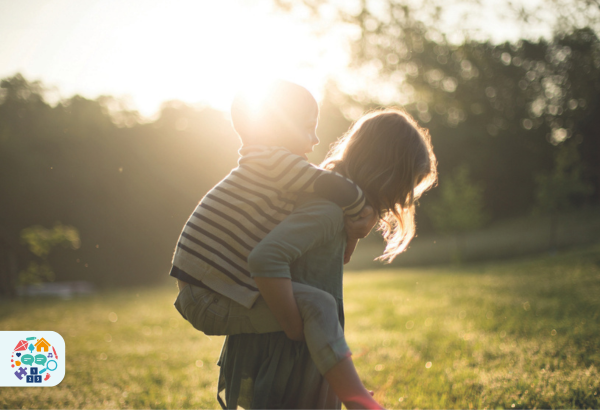 Adult giving child a piggy back