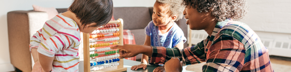 an adult with two children with an wooden abacus