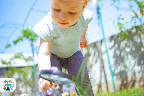 Early Years Wales launches ambitious manifesto for the Early Years Image of a child examining flowers with a magnifying glass