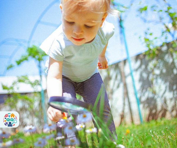 Image of a child examining flowers with a magnifying glass