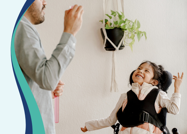 Early Years Wales Member Roadshow (South) Image of a adult blowing bubbles for a child with cerebral palsy
