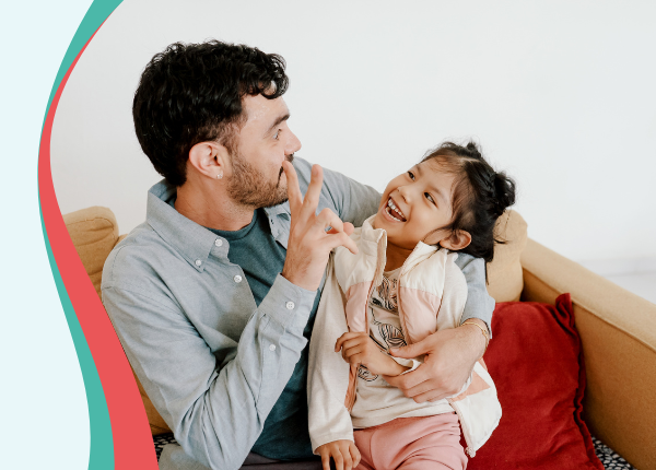 Early Years Wales Member Roadshow A child sat in an adults lap, they are smiling at each other