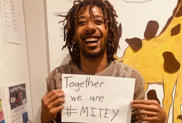 Smiling gentleman holdonhg a Together we are #Mitey card