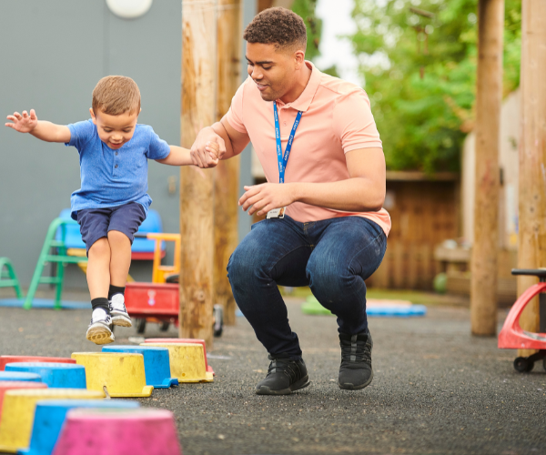 Adult helping child play on blocks