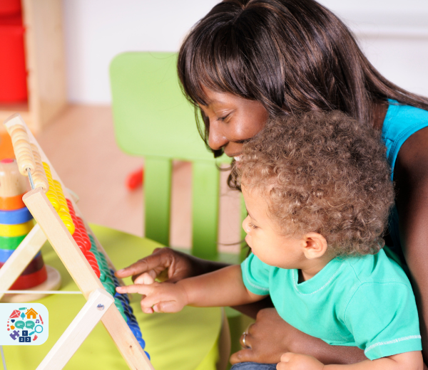 Adult wearing a blue tank top holding child wearing a blue top adds up using an abacus