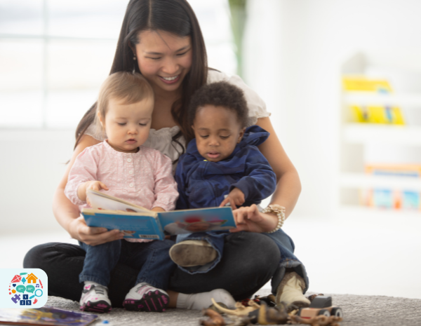 Picture of an adult reading a book to two babies who are sat on her lap
