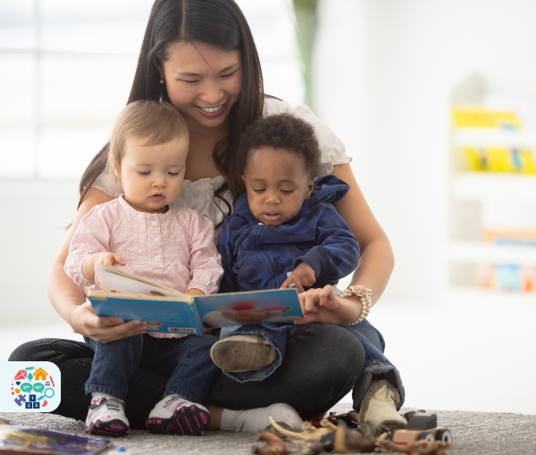 Picture of an adult reading a book to two babies who are sat on her lap