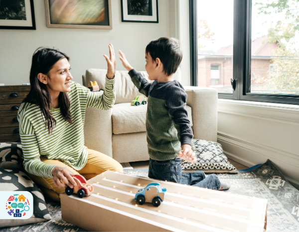 Adult and child smiling at each other while reading a book