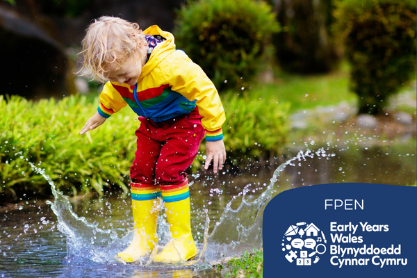 Child wearing brightly coloured clothes jumps in puddles