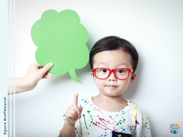 Child wearing red glasses points up to a speech bubble