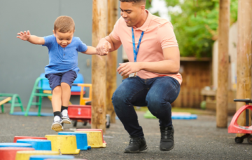 Adult helping child play on blocks