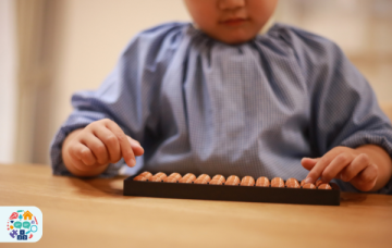 Child counting on an abacus that is flat to the table