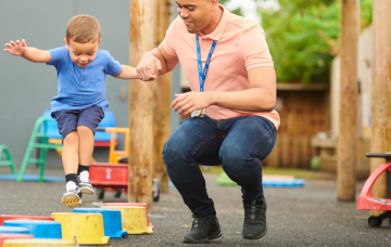 Adult helping child play on blocks