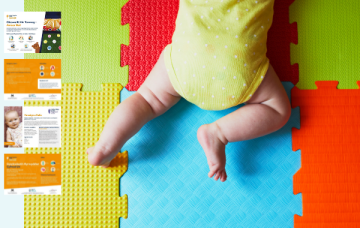 Baby in a yellow and white polka dot babygrow doing tummy time on colourful mats