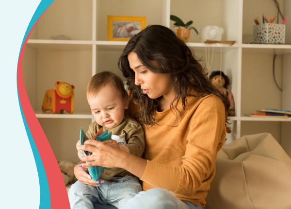 An image of an adult reading a book to a baby
