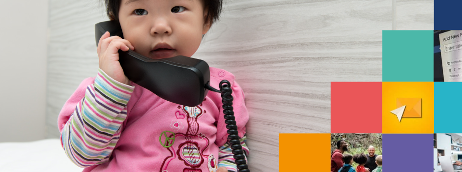 Colourful boxes on a background of a beautiful toddler wearing a pink romper holding a phone